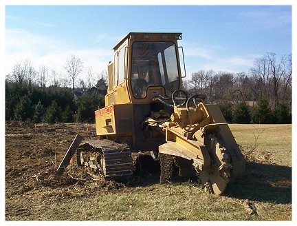 A track loader with a stump grinding attachment