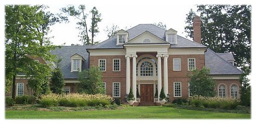 A luxury custom home with a hip roof, columns, and dormers