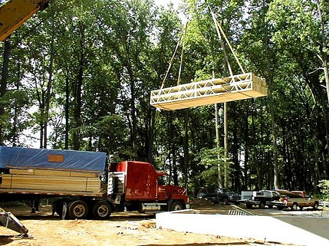Floor trusses being unloaded from the delivery truck using a crane