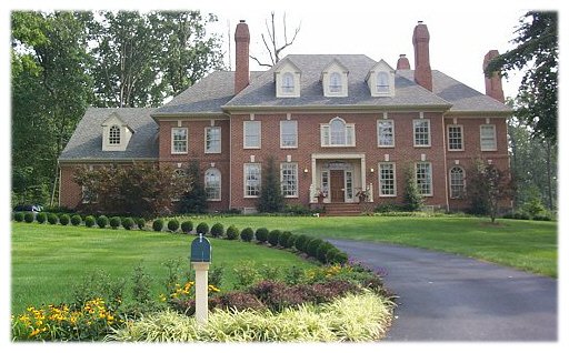 A luxury custom home with a fountain in front