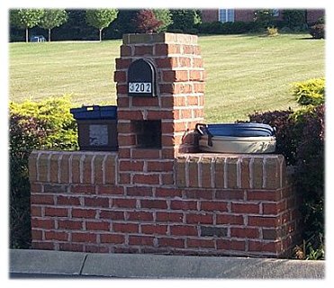 A custom brick mailbox with trash bins