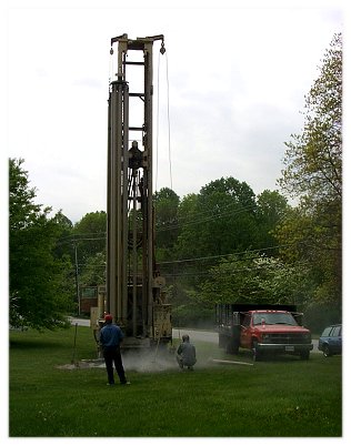 Well drillers tend a well driling rig.